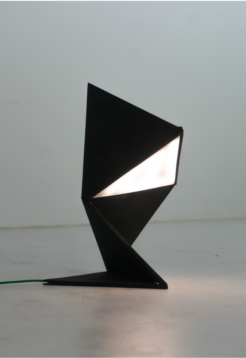 Folded black desk lamp with an illuminated triangular light panel